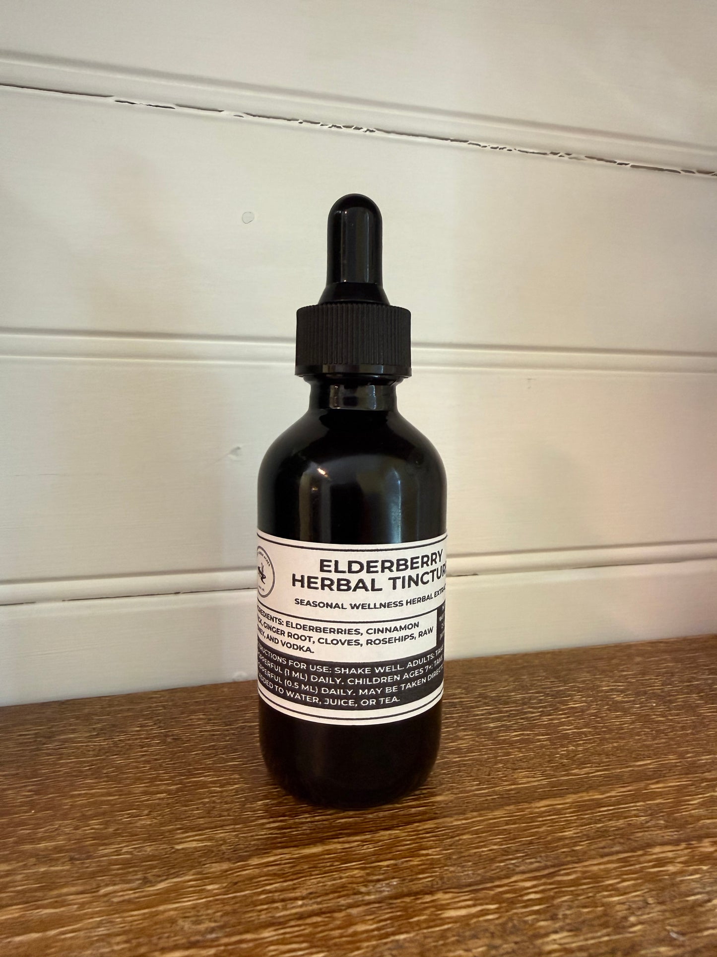 Black bottle with a dropper on a wooden surface elderberry tincture