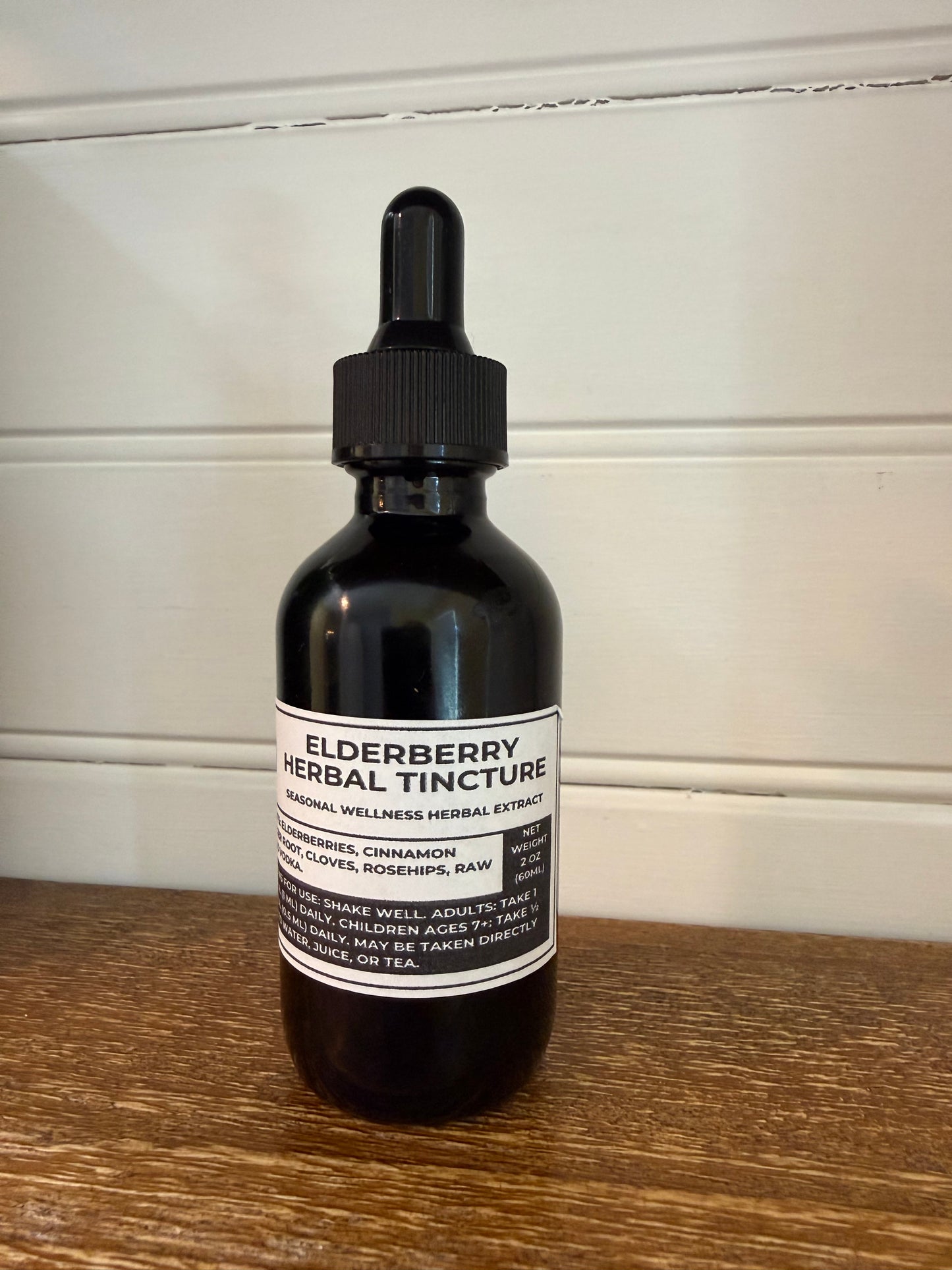 Bottle of elderberry herbal tincture on a wooden surface
