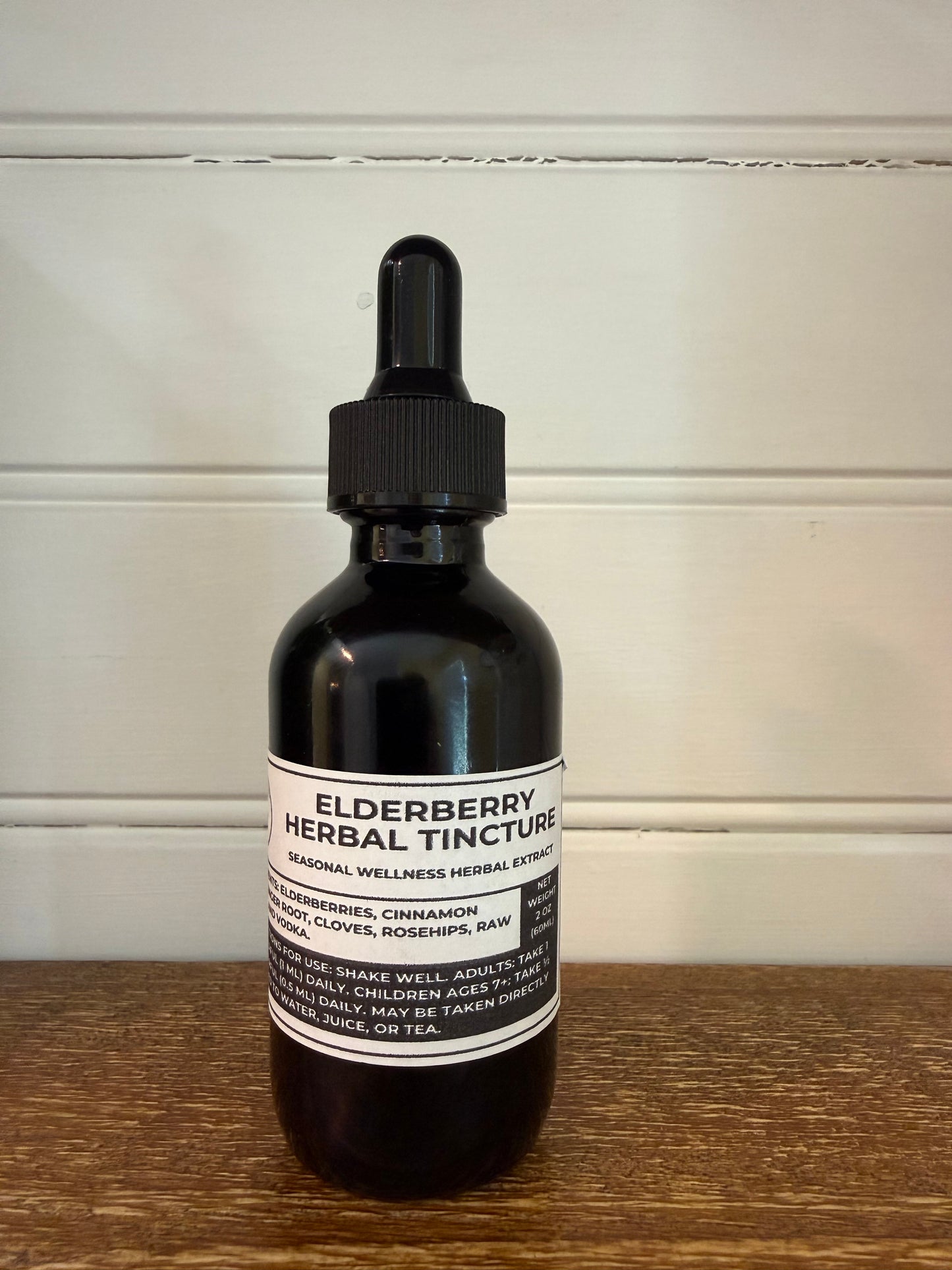 Bottle of elderberry herbal tincture on a wooden surface