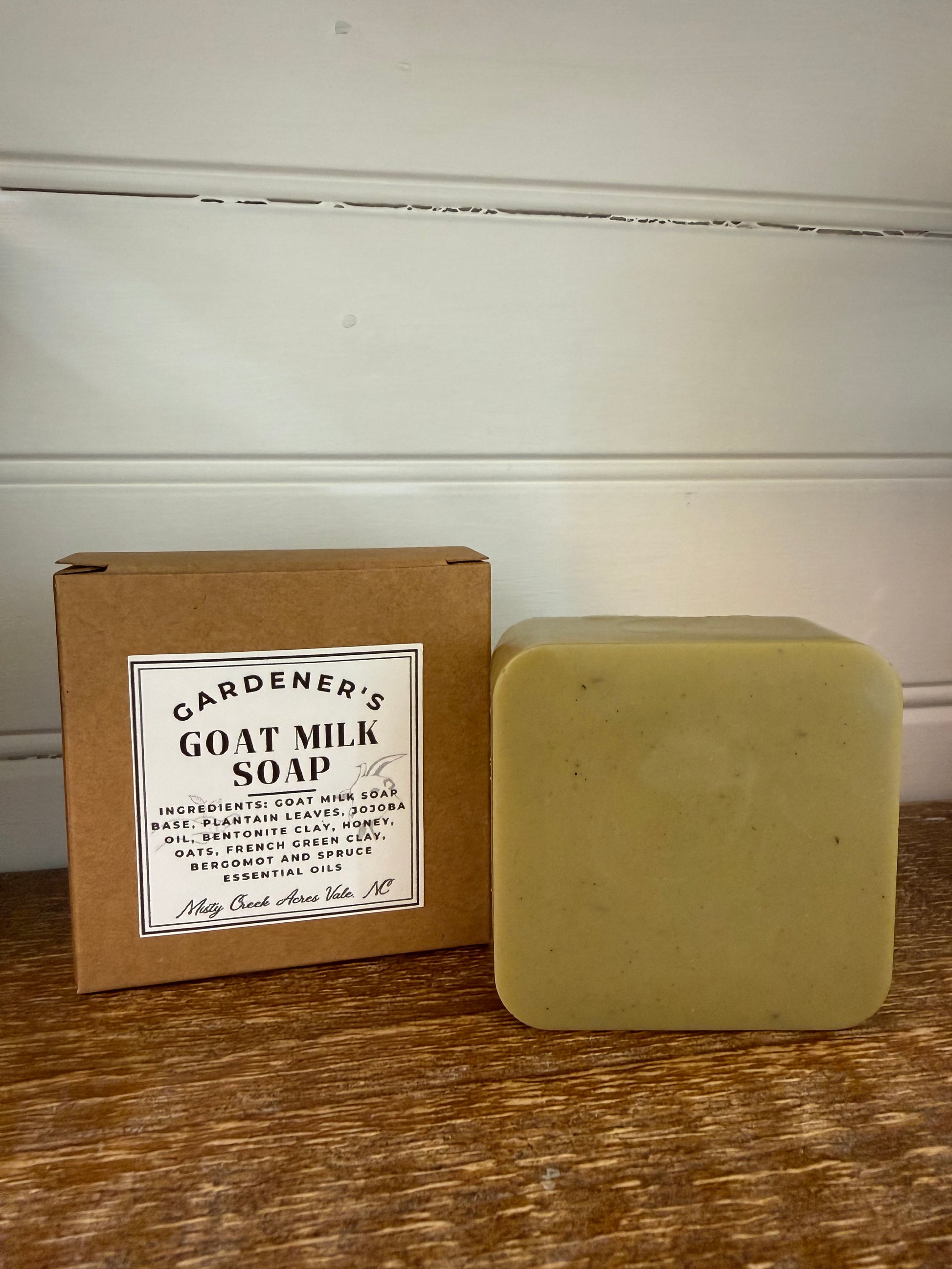 Bar of soap on a cardboard box with a label on a wooden surface