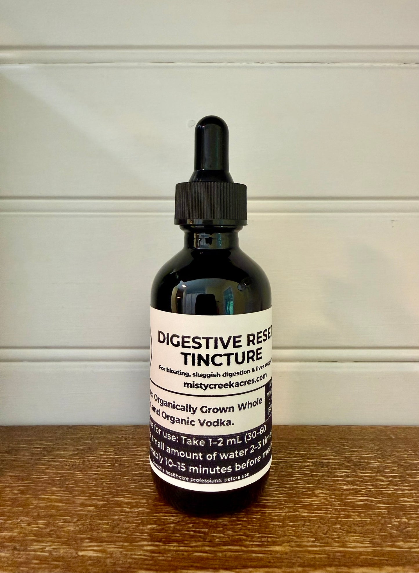 Bottle of Digestive Reserve Tincture on a wooden surface with a white background