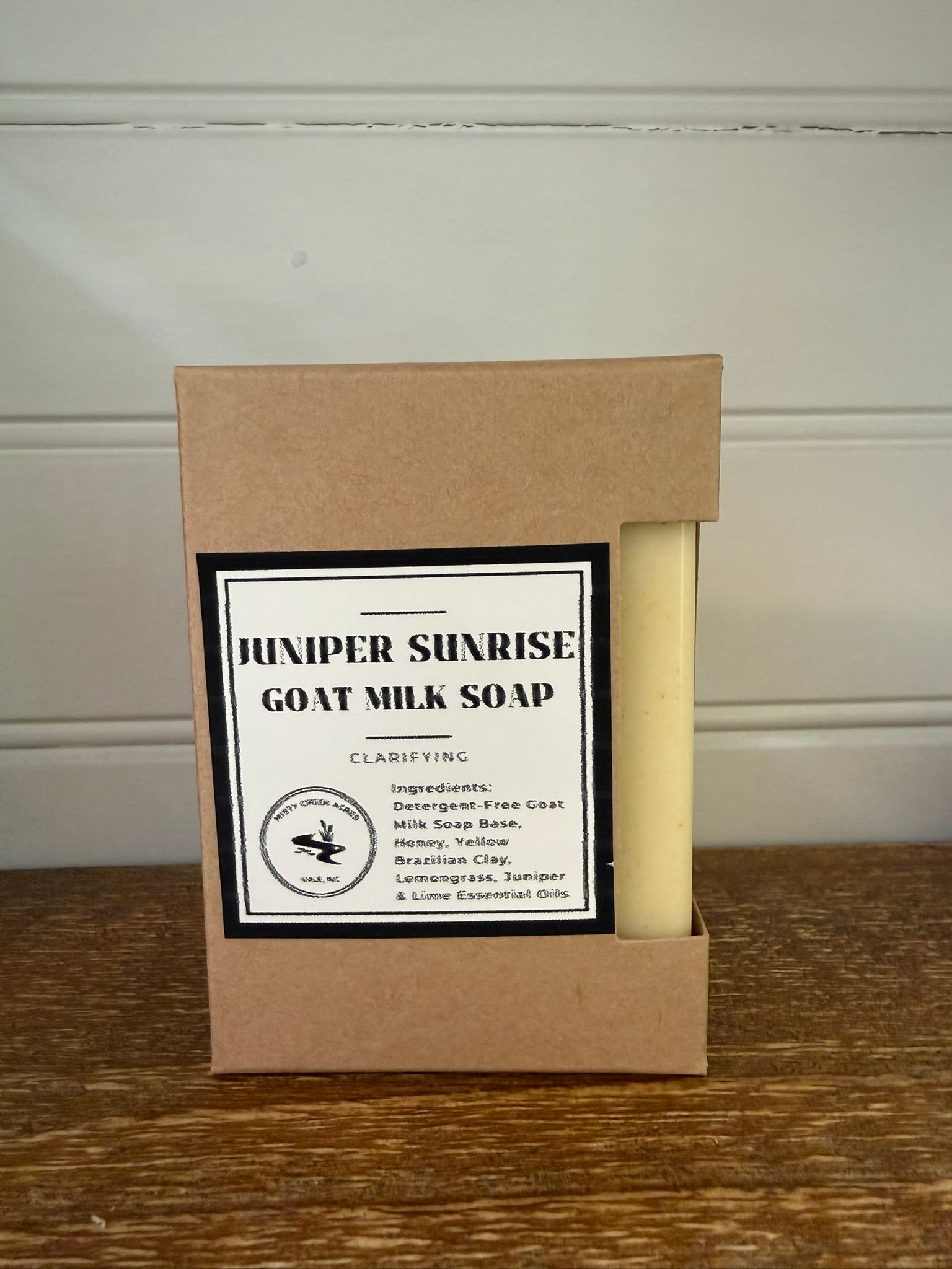 Goat milk soap in a brown box with a label on a wooden surface.