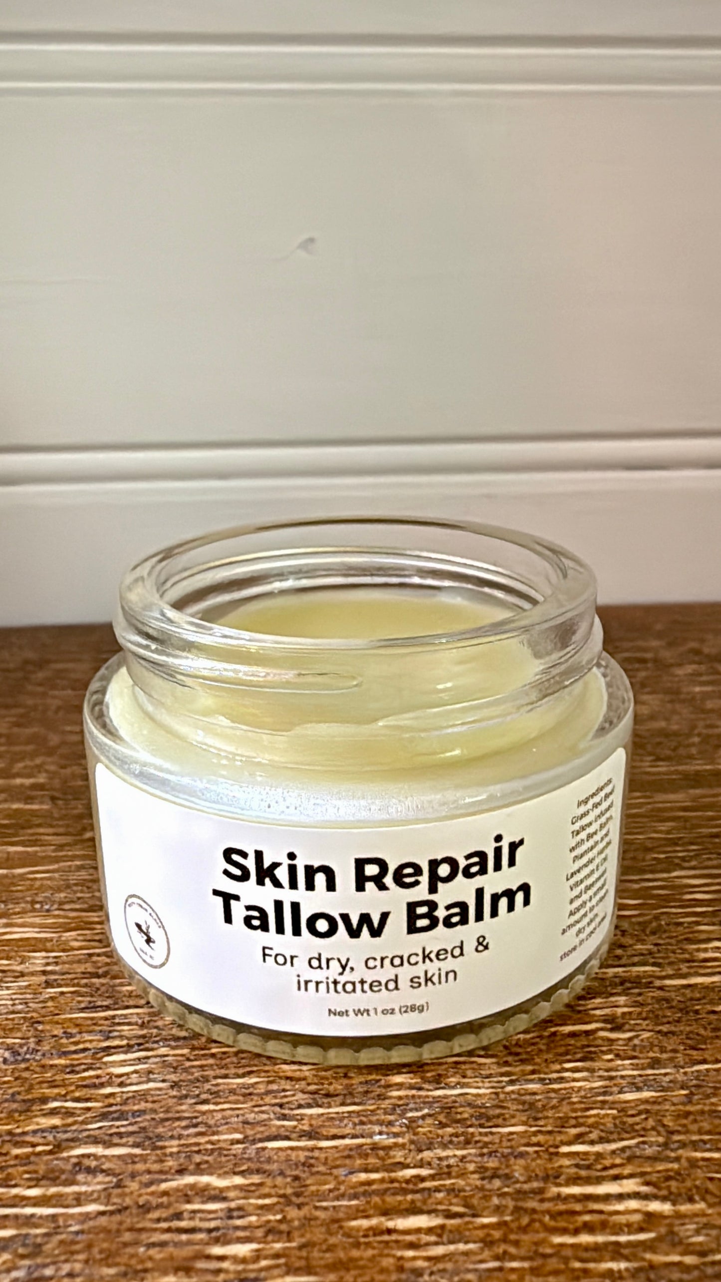 Jar of Skin Repair Tallow Balm on a wooden surface with a neutral background