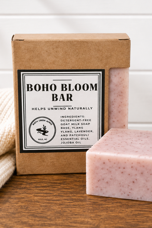 Pink soap bar next to a cardboard box labeled 'Boho Bloom Bar' on a wooden surface.