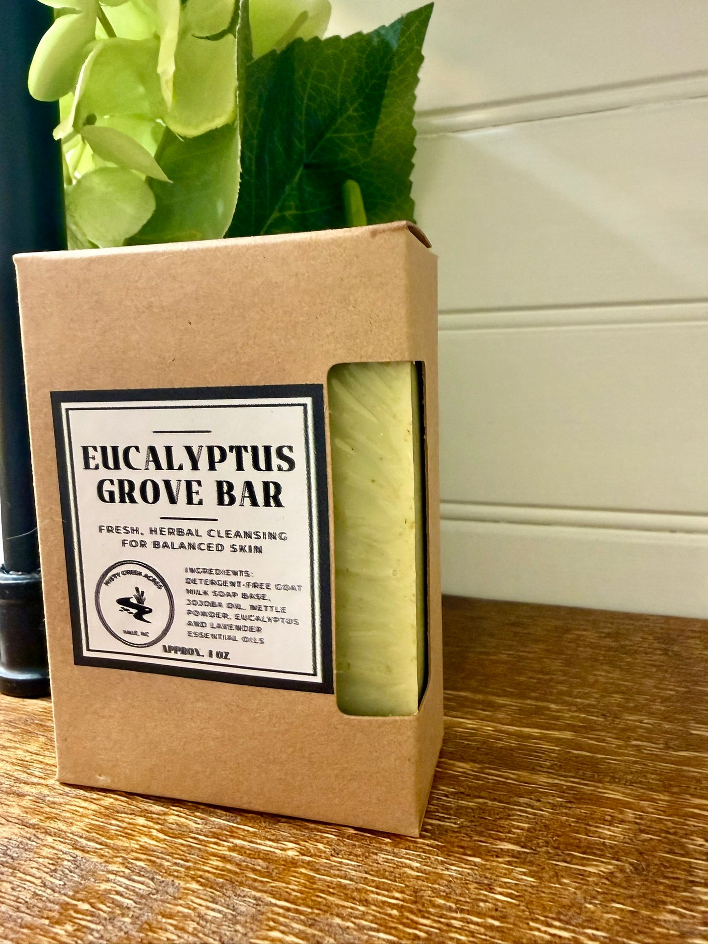 Eucalyptus Grove bar soap in a brown cardboard box on a wooden surface.