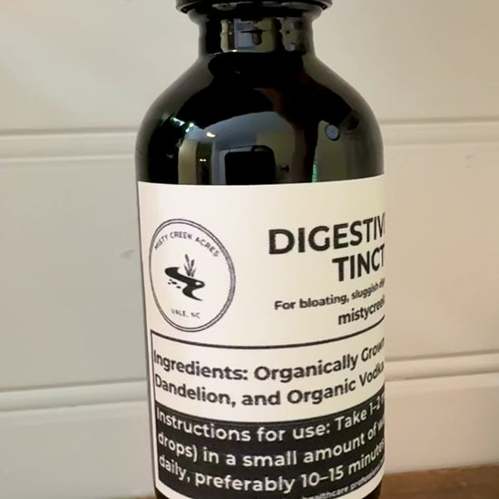 Bottle of digestive tincture on a wooden surface with a white wall background