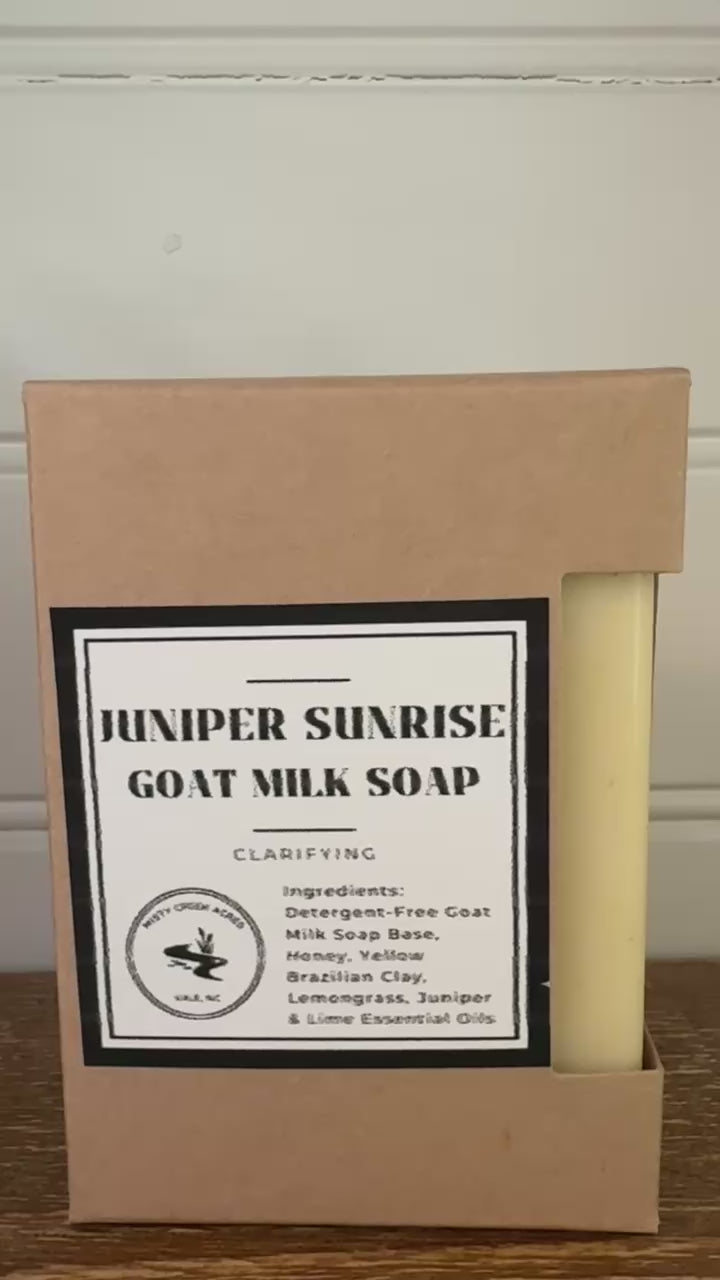 Bar of soap and its packaging with 'Hexxer Sunrise Goat Milk Soap' label on a wooden surface.
