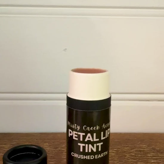 Balm with a black container on a wooden surface