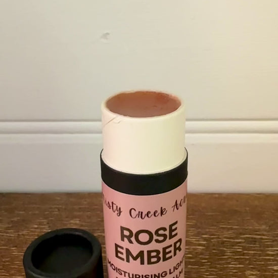 Lip balm with pink label on a wooden surface
