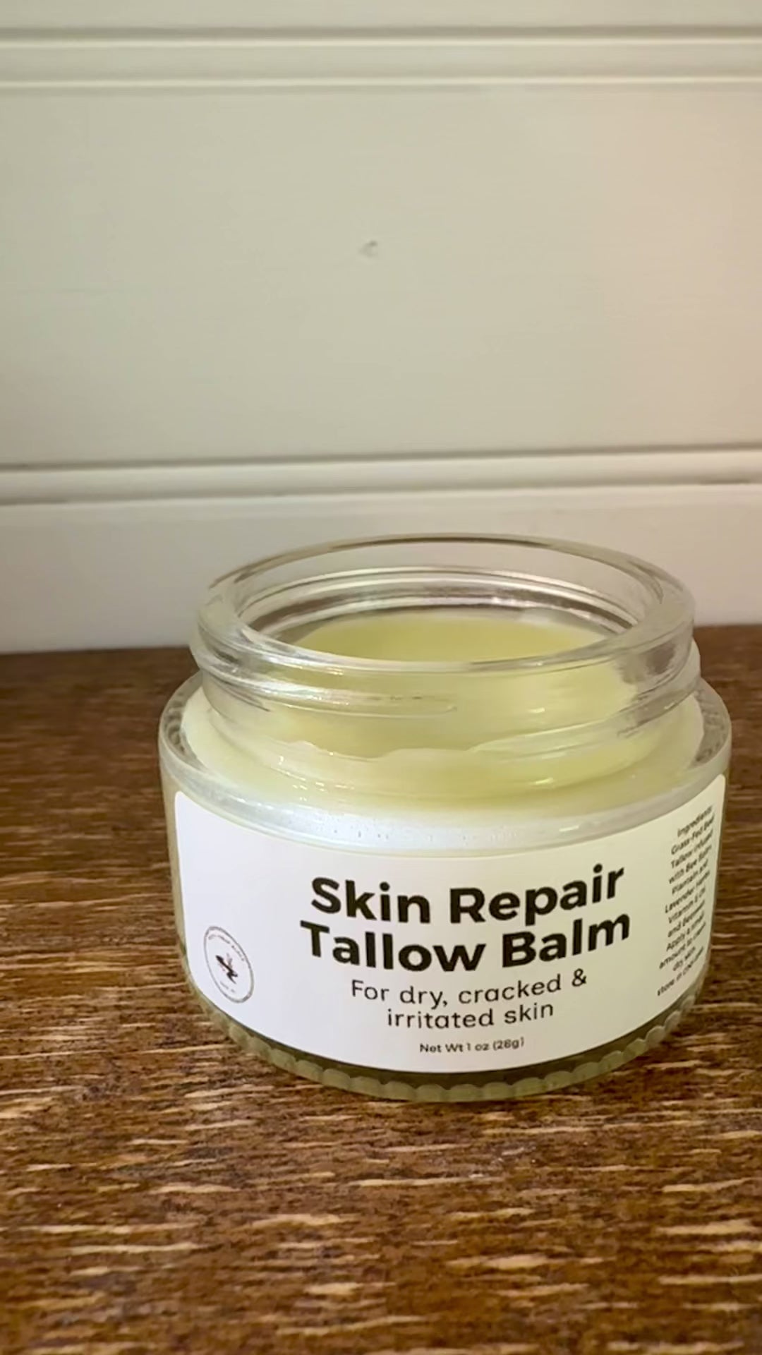 Jar of Skin Repair Tallow Balm on a wooden surface with a neutral background